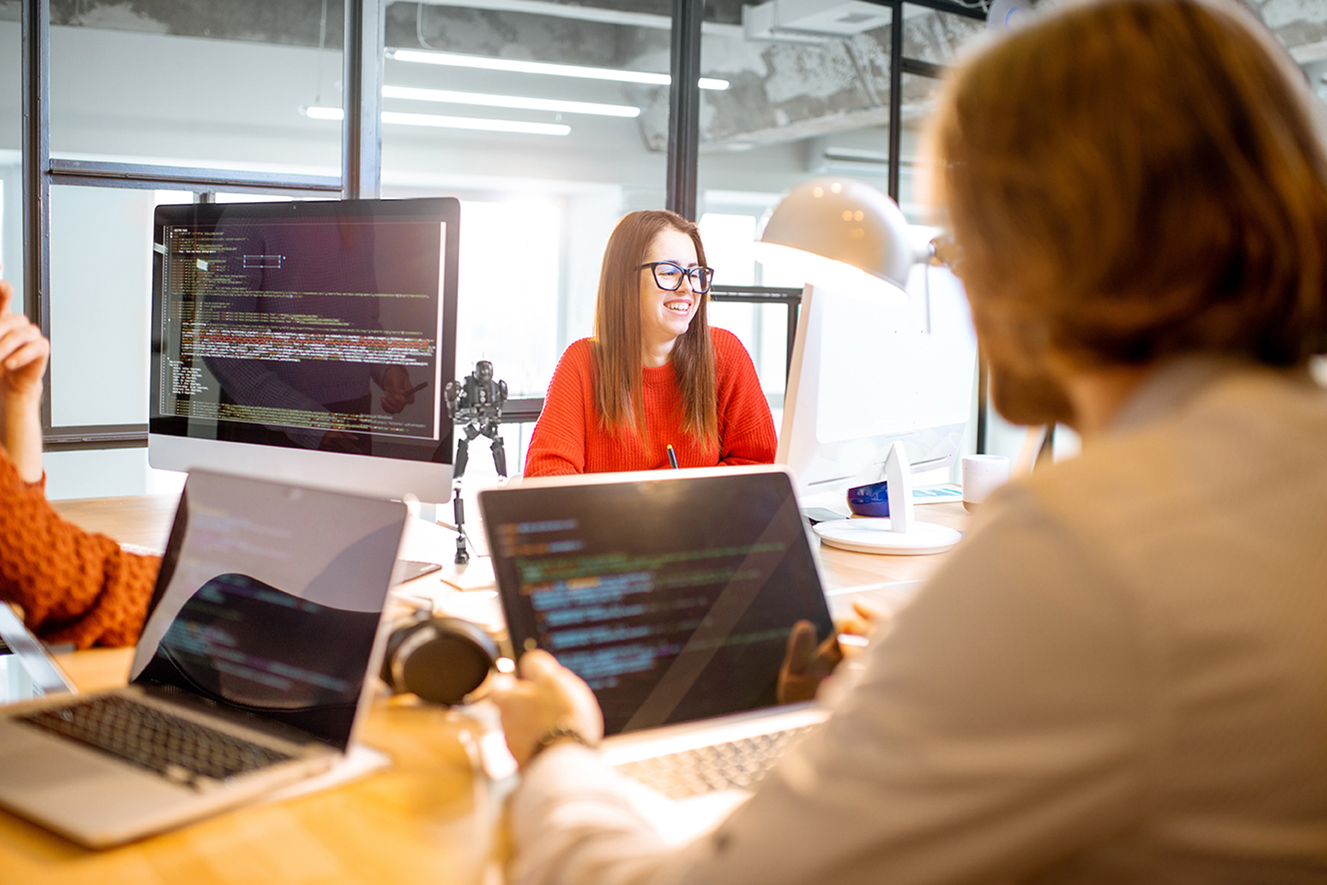 Glad programmerare i rum med många dataskärmar